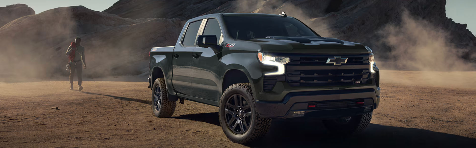 Black Chevrolet Silverado truck in a rugged landscape.